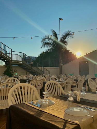 a wooden table with white chairs and a tableasteryasteryasteryasteryasteryasteryastery at La Masseria Hotel Ristorante Centro Benessere in Cocumola