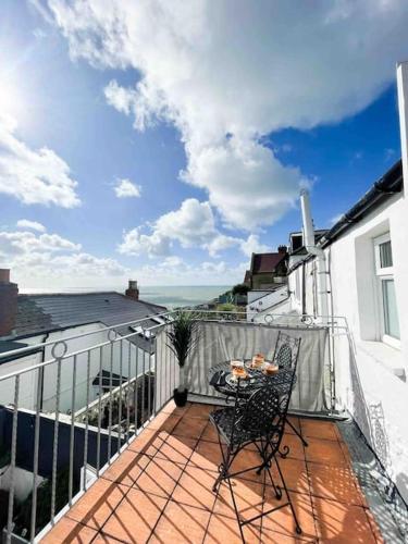 a patio with a table and chairs on a balcony at *Stunning* The Botanist Rest Ventnor IOW in Ventnor