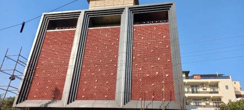 a tall red brick building with a large window at Square9 - A Boutique Hotel in Gurgaon