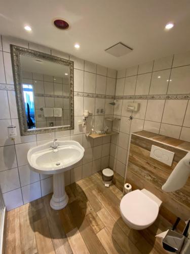 a bathroom with a sink and a toilet and a mirror at Arthotel ANA Residence Bremen in Bremen