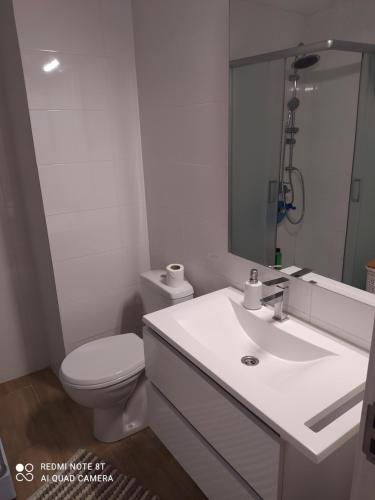 Baño blanco con aseo y lavamanos en Apartman 9, en Voždivac