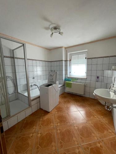 W łazience znajduje się umywalka, prysznic i wanna. w obiekcie Wohnung für Monteure in Unterallgäu 