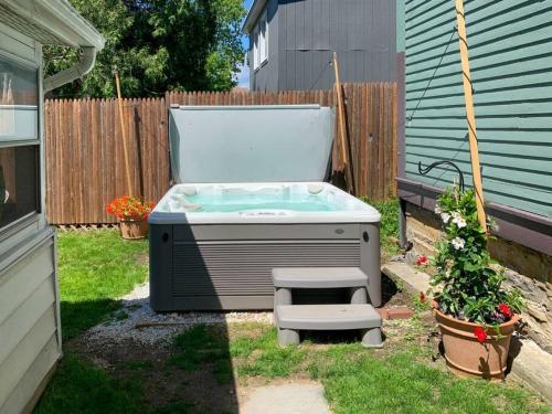 a hot tub in a yard next to a fence at Bohemian Bungalow with Hot Tub in Winooski