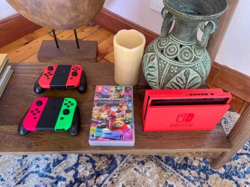 two video game controllers and a box on a table at Bohemian Bungalow with Hot Tub in Winooski