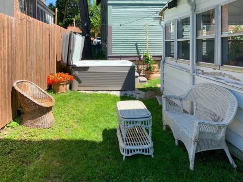 a yard with two chairs and a table and a fence at Bohemian Bungalow with Hot Tub in Winooski