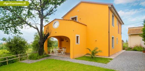 a yellow house with an archway in a yard at Agriturismo La Pineta in Fucecchio