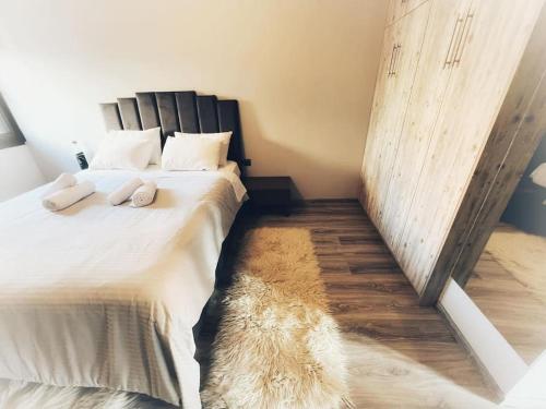 a bedroom with a large bed with white sheets and a rug at The Beehive in Mytilene