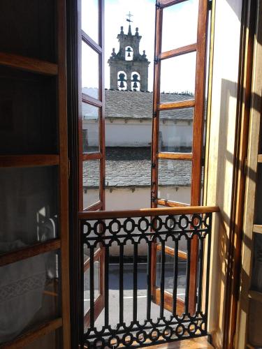 an open window with a view of a church at HOTEL RURAL OSCOS in Villanueva de Oscos