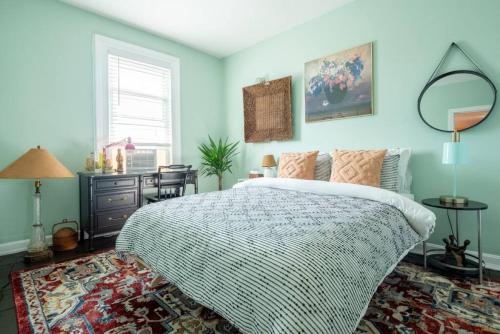 a bedroom with a bed and a table and a mirror at Postmodern Penthouse 1 Min Walk Dining and Shops in Winooski