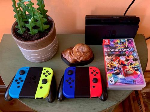 a table with two video game controllers and a game box at Postmodern Penthouse 1 Min Walk Dining and Shops in Winooski