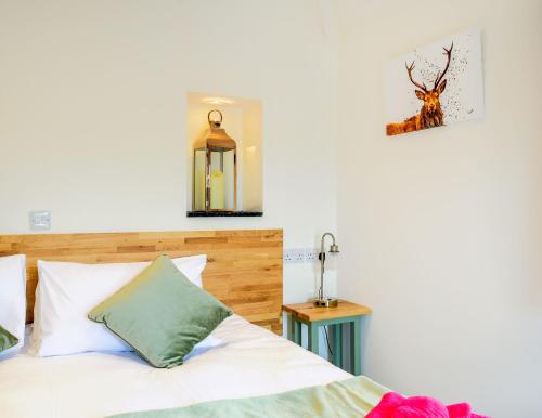 a bedroom with a bed and a lamp at The Old Stables at Castle Chase, Ayston in Uppingham