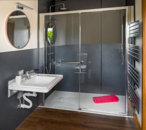 a bathroom with a sink and a glass shower at The Old Stables at Castle Chase, Ayston in Uppingham