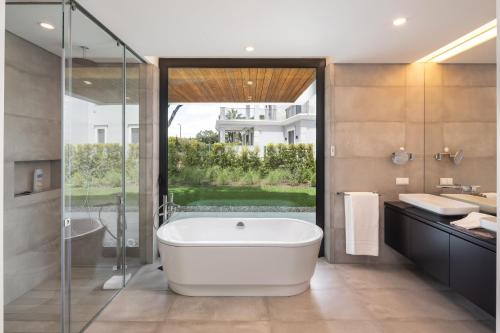 a bathroom with a tub and a shower and a sink at Vale do Lobo Sky Villa by Homing in Vale do Lobo
