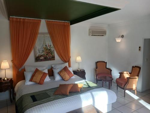 a bedroom with a large bed with orange curtains at HOTEL LA COGNETTE A 25 Kilomètres de Châteauroux et 30 Kilomètres de Bourges in Issoudun