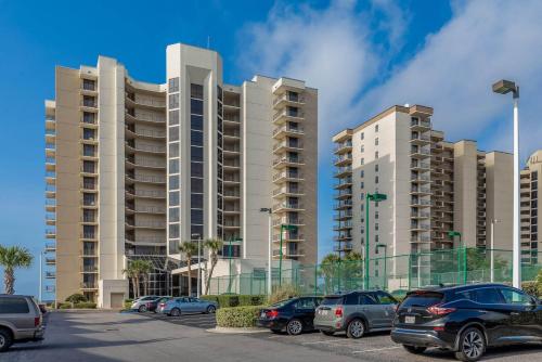 a parking lot with cars parked in front of tall buildings at Phoenix VIII by Brett Robins Vacations in Orange Beach