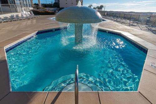 a pool with a fountain in the middle of a building at Standard Apartment in Orange Beach