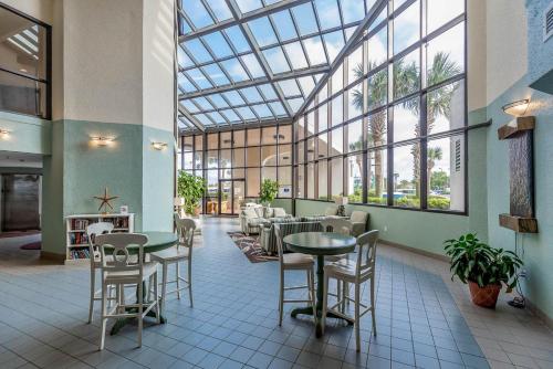a restaurant with tables and chairs and a glass ceiling at Standard Apartment in Orange Beach