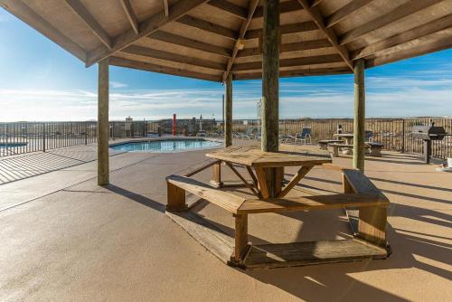a picnic table and a bench under a pavilion at Phoenix VIII by Brett Robins Vacations in Orange Beach