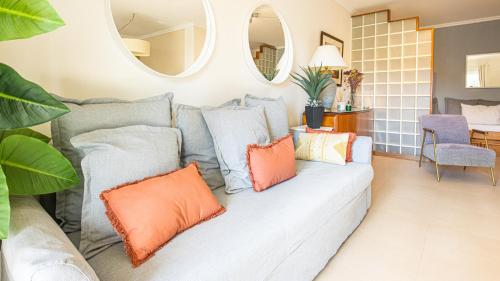 a living room with a gray couch with orange pillows at Place in the sun - Free out door Jacuzzi - BY BEDZY in Albufeira