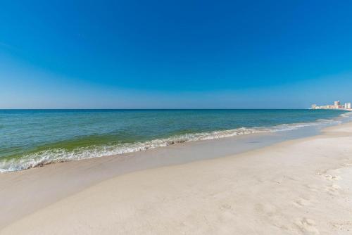a sandy beach with the ocean in the background at One-Bedroom Apartment in Orange Beach