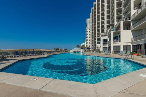 a large blue swimming pool in front of a building at One-Bedroom Apartment in Orange Beach