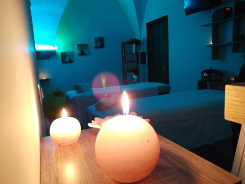 two candles sitting on a table in a living room at La Masseria Hotel Ristorante Centro Benessere in Cocumola