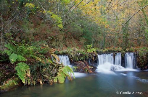 a waterfall in the middle of a river at HOTEL RURAL OSCOS in Villanueva de Oscos