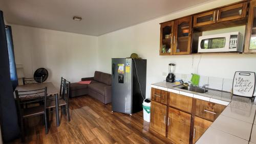 a kitchen with a refrigerator and a table and a couch at Casa Lapa Delicias in Montezuma