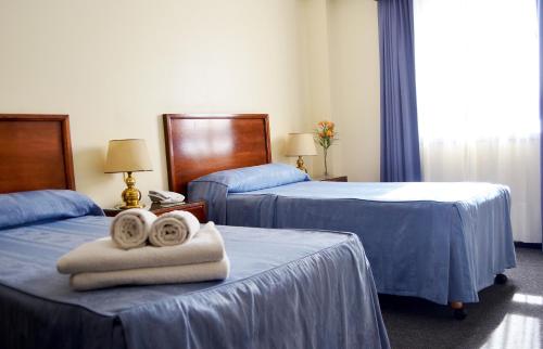 Habitación de hotel con 2 camas y toallas. en Hotel Centro Naval en Buenos Aires
