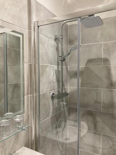 a shower with a glass door in a bathroom at The Old Lodge Guest House in Lincoln