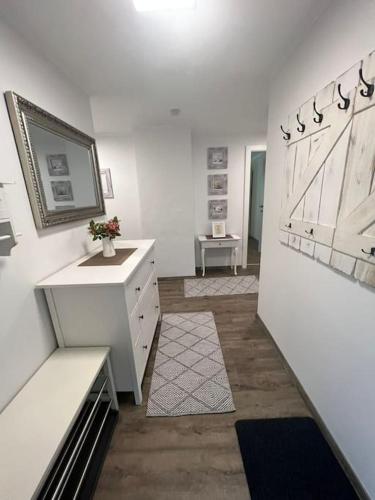 a white room with a desk and a dresser at Gemütliche Wohnung in Velden! in Velden am Wörthersee