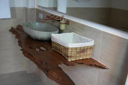 a bathroom with a sink and a basket on a table at Aldea Tipi: El Molino de Aldebarán in Villa de Leyva