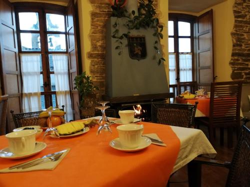 a dining room with a table with an orange table cloth at HOTEL RURAL OSCOS in Villanueva de Oscos