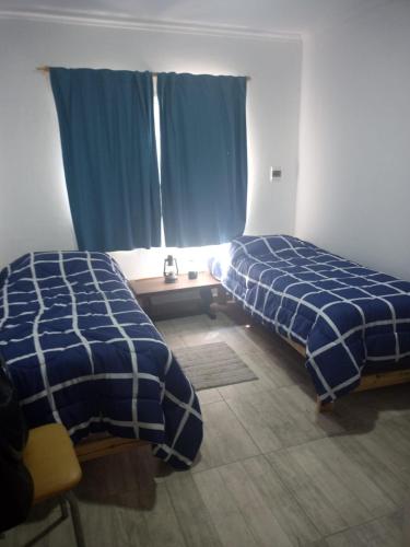 2 camas en una habitación con sábanas azules y blancas en Mukanga en San Pedro