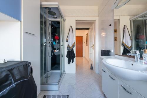 uma casa de banho com uma cabina de duche em vidro e um lavatório. em poetto Quartu em Quartu SantʼElena