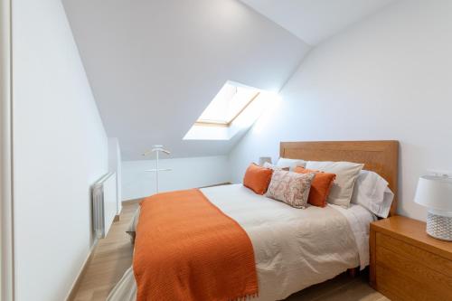 um quarto com uma cama com um cobertor laranja em Apartamento Solpor Bueu em Bueu