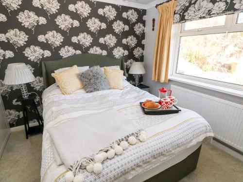 a bedroom with a bed with a tray of food on it at 1 Gloucester Way in Pembroke Dock