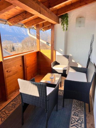 a patio with chairs and tables and a large window at Gruberhof in Pill