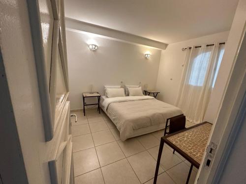 a bedroom with a bed and two tables and a window at Keur RAMYBĖ in Sali Nianiaral