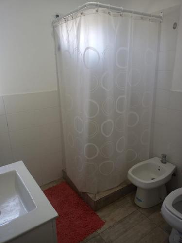 y baño con cortina de ducha y aseo. en Mukanga en San Pedro