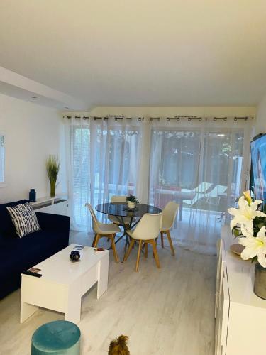 un salon avec un canapé, une table et des chaises dans l'établissement 3 pièces terrasse, jardin, à Cannes