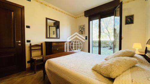 ein Schlafzimmer mit einem Bett und einem großen Fenster in der Unterkunft Villa Felice in San Felice del Benaco