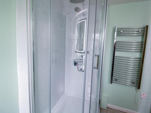 a shower with a glass door in a bathroom at Dolwen in Betws-y-coed