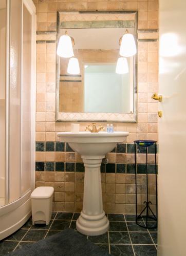 a bathroom with a sink and a mirror and a toilet at Luxury Chez-Moi in Serres