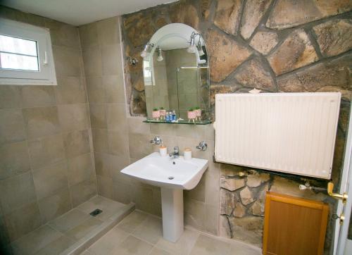 a bathroom with a sink and a stone wall at Luxury Chez-Moi in Serres