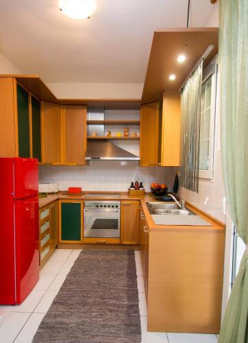 a kitchen with wooden cabinets and a red refrigerator at Luxury Chez-Moi in Serres