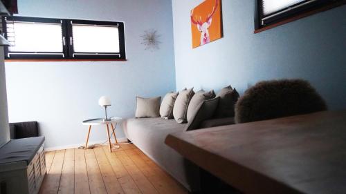 ein Wohnzimmer mit einem Sofa und einem Tisch in der Unterkunft FERIENHAUS am HAINER SEE in Neukieritzsch