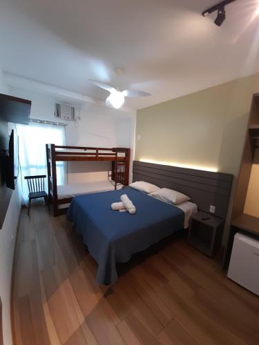 a bedroom with a blue bed and a bunk bed at Pousada Velas do Forte in Cabo Frio