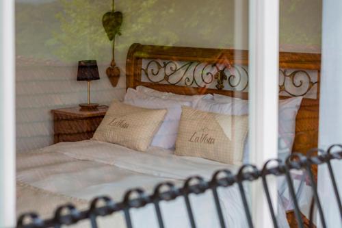 uma cama com lençóis brancos e almofadas em Pousada La Vista em Gramado