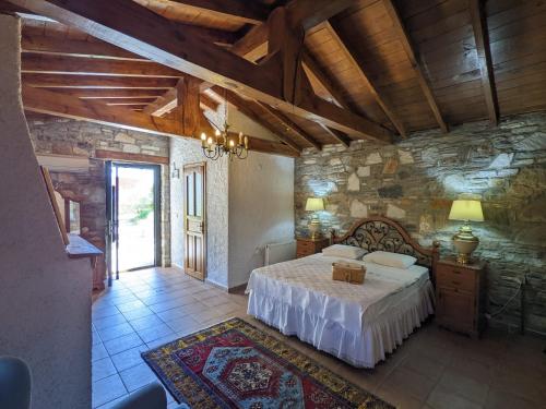a bedroom with a bed and a stone wall at Bahab Guest House in Doğanbey